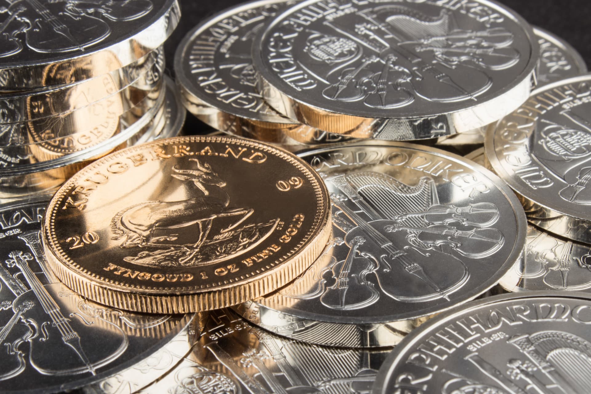 Goldmünze Krügerrand zwischen Silbermünzen Wiener Philharmoniker