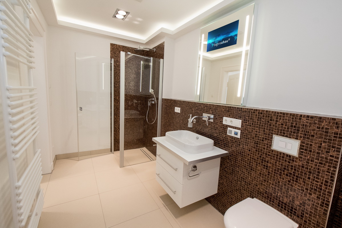 Badezimmer mit Mosaikfliesen, Lichtspiegel und bodengleicher Dusche