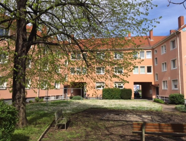 Wohnanlage mit begrüntem Innenhof und altem Baumbestand